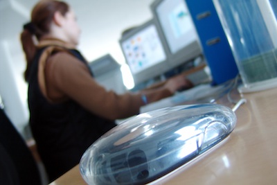 Young woman working on a computer screen responding to an inappropriate email